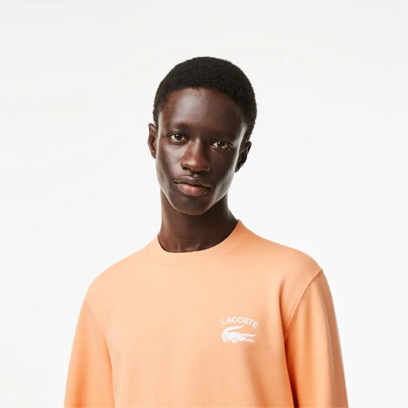 SWEATSHIRT ORANGE COL ROND AVEC INSCRIPTION DANS LE DOS LACOSTE